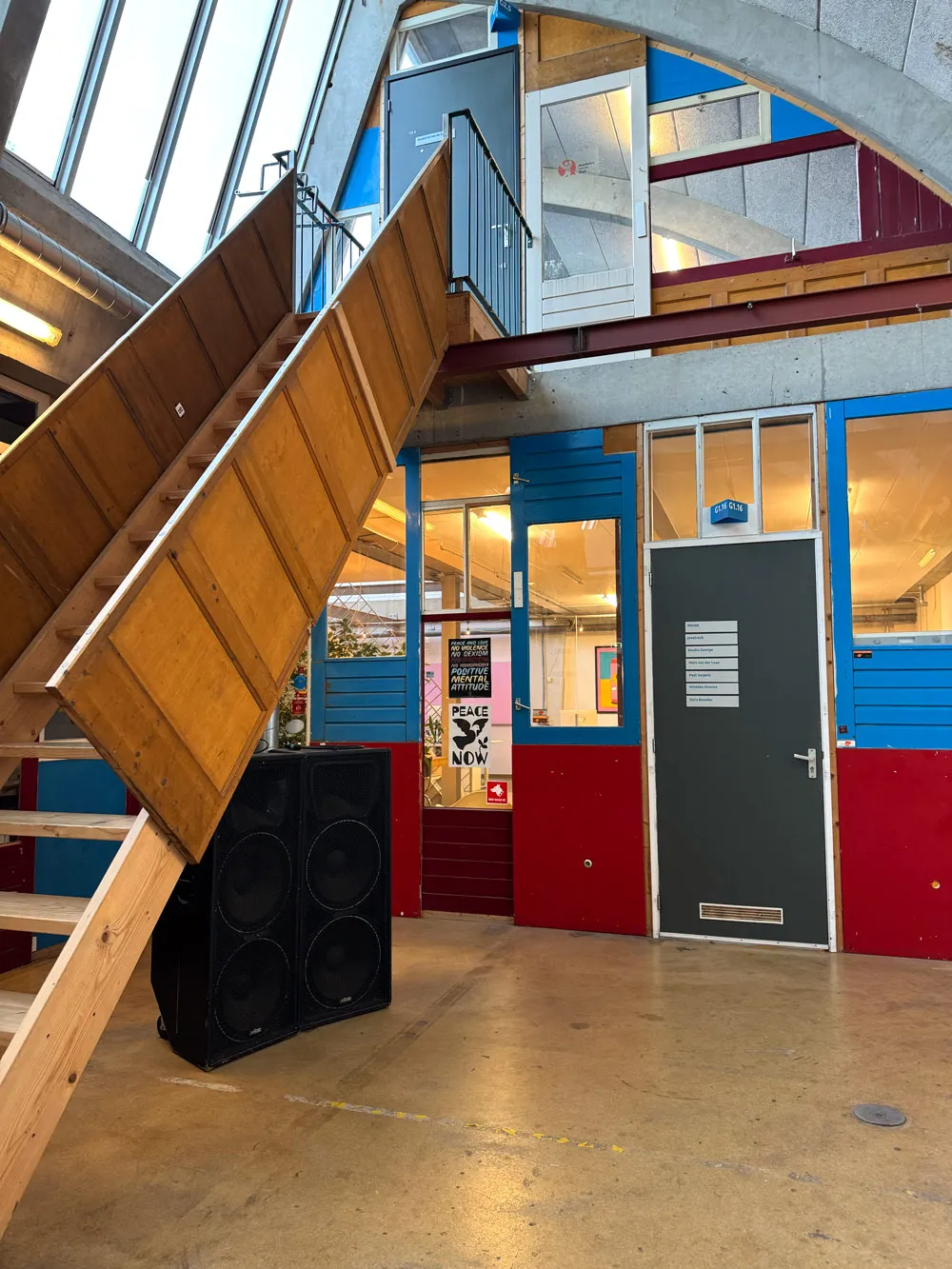 hal met houten trap en gekleurde gevels