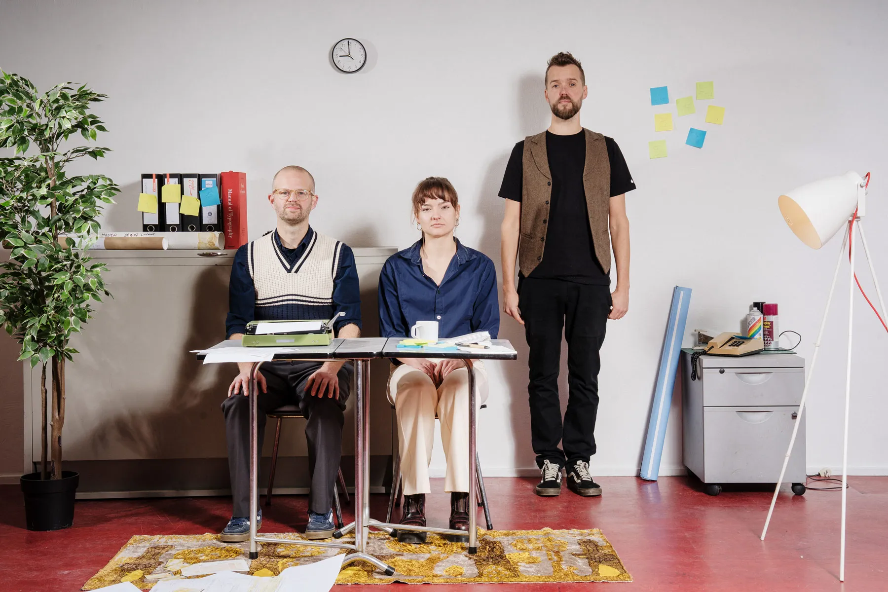 het team van Vrije Stijl: twee mensen aan een bureau en een man die ernaast staat
